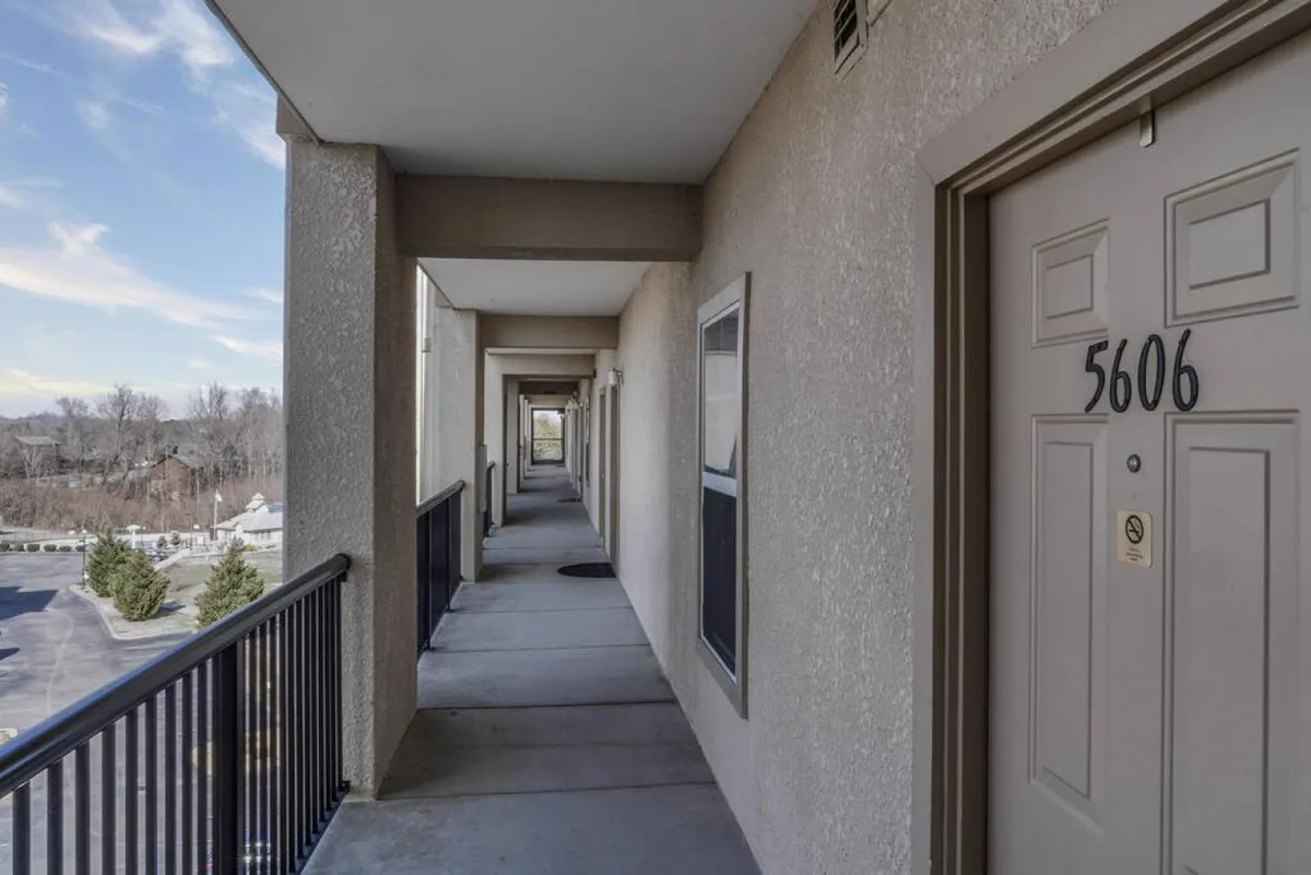 This exterior image captures a welcoming doorway and hallway, with an accessible path leading to the unit. The outdoor view and step-free entry highlight the ease of access for guests of all ages and mobility levels.