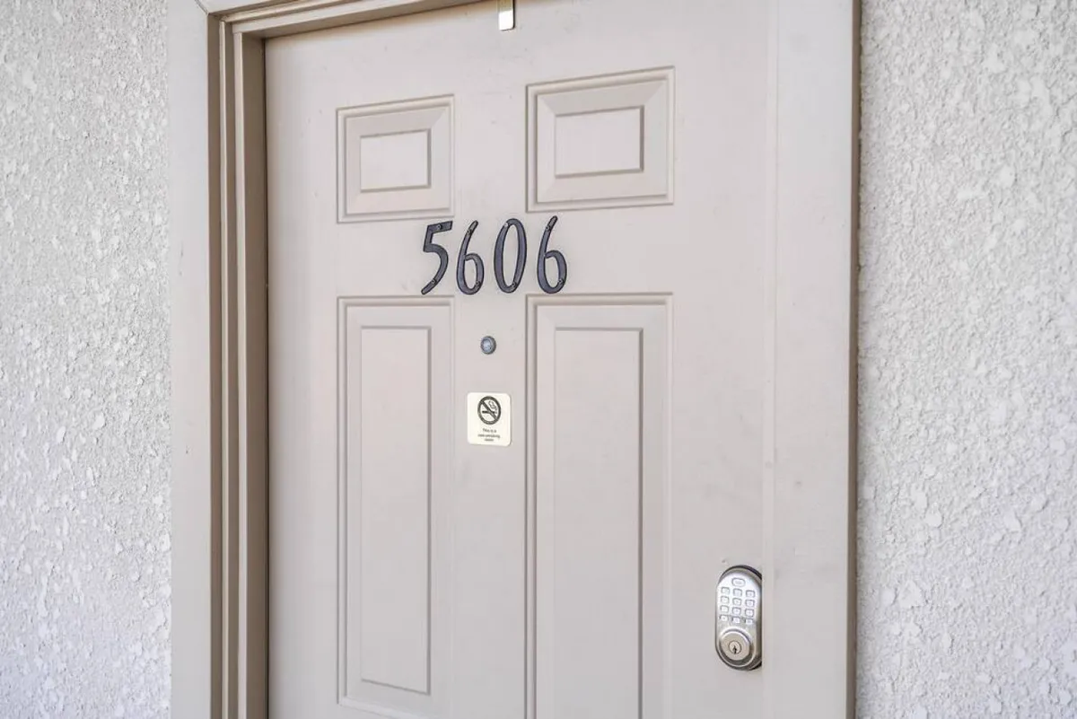The entry door to unit 5606 features a keypad entry system and no-step threshold, symbolizing both security and accessibility. The clear labeling and modern access underline ease of arrival for families and groups.