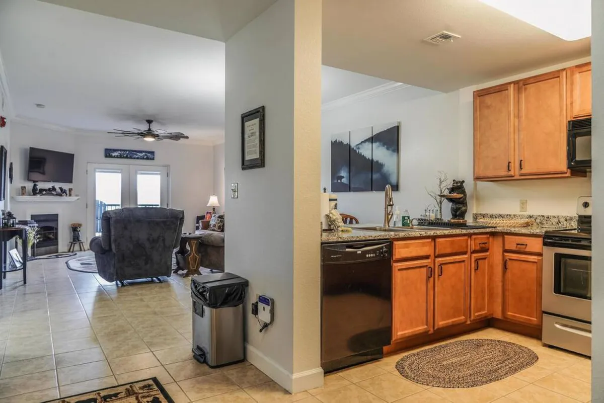 An open-concept area presenting the kitchen, dining, and living spaces together. The kitchen area is visible with modern amenities, while the dining table and comfortable living area foster a sense of connection, conversation, and shared experiences.
